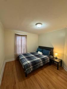 a bedroom with a bed and a table and a window at Comforting getaway-sleeps 6-walk to falls! in Niagara Falls