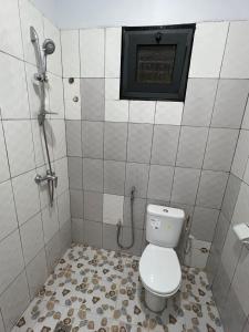 a bathroom with a toilet and a shower at Zombré in Ouagadougou