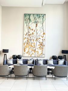 une salle d'attente avec des chaises et un tableau sur le mur dans l'établissement The Trilogy Apartment MM 51011, à Pretoria