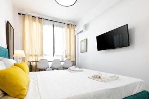 een hotelkamer met een bed en een televisie aan de muur bij Vibrant Studio Close To Panepistimio Metro-Zaloggou str in Athene