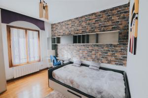 - une chambre avec un mur en briques et un lit dans l'établissement Apartamento Siervas de Jesús, à Haro
