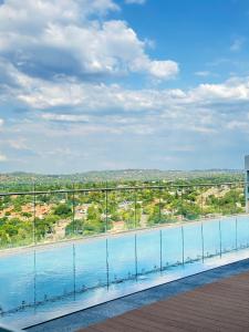 a swimming pool with a view of the city at The Trilogy Apartment MM 51011 in Pretoria
