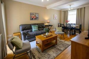 a living room with a couch and a table at Heritage Cottage by StayStaycations in Pontypridd