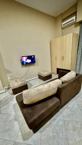 a living room with a couch and a flat screen tv at Eno’s Apartment 2 in Vlorë