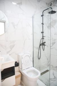 a white bathroom with a shower and a toilet at Apartments Murdzoski in Struga