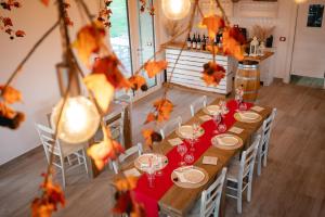 een eetkamer met een lange tafel met wijnglazen bij Agriturismo La Guarda in Picedo