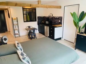 1 Schlafzimmer mit einem großen Bett und einer Küche in der Unterkunft Chambre à la Noye in Estrées-sur-Noye