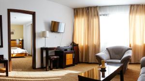 a hotel room with a desk and a bedroom at HOTEL CRISS in Bucharest