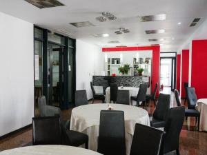 a dining room with tables and chairs and a bar at HOTEL CRISS in Bucharest