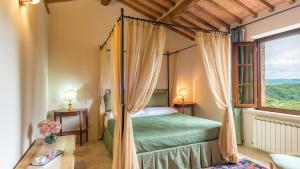a bedroom with a canopy bed and a window at Villa Le Chiarne 22, Emma Villas in Asciano +37 photos