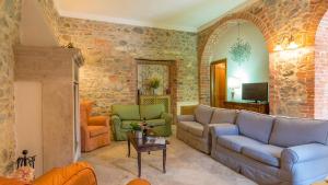 a living room with a couch and chairs at Villa Le Chiarne 22, Emma Villas in Asciano