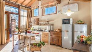 uma cozinha com um frigorífico de aço inoxidável e uma mesa em Villa Le Chiarne 22, Emma Villas em Asciano
