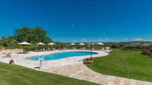 a swimming pool with chairs and umbrellas at Villa Le Chiarne 22, Emma Villas in Asciano