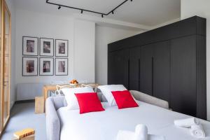 una camera da letto con un grande letto bianco con cuscini rossi di Modern Loft in Paris Montreuil a Montreuil