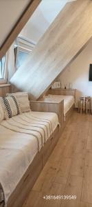 two beds in a room with an attic at NevSki Apartments in Kopaonik
