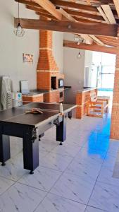Una mesa de ping pong en una habitación con chimenea. en M&S eventos, en Itanhaém
