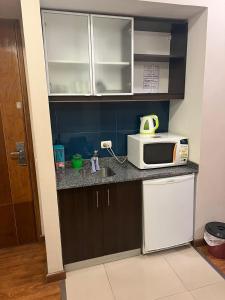 a kitchen with a microwave and a sink at Dto Civico ART APARMENT in San Juan