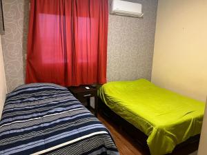 a room with two beds and a red curtain at Dto Civico ART APARMENT in San Juan