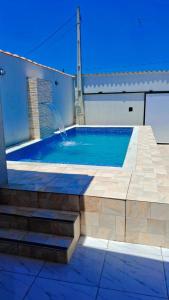 una piscina con escaleras y una fuente de agua en M&S eventos, en Itanhaém