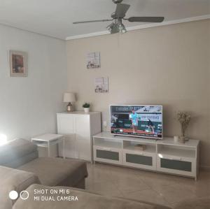 ein Wohnzimmer mit einem Flachbild-TV auf einem Schrank in der Unterkunft Bungalows in San Juan: with Pool and Close to Muchavista Beach in San Juan de Alicante