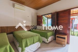 duas camas num quarto com lençóis verdes em Casa no Ceará a 15 min da Praia da Canoa Quebrada em Aracati