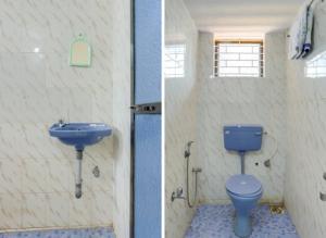 Radhabai Hotel في أرامبول: حمام به مرحاض أزرق ومغسلة
