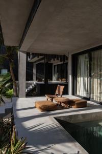 a house with a swimming pool and two chairs next to a swimming pool at Umi Tulum in Tulum