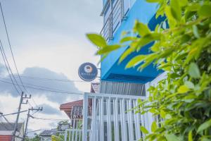 un edificio blu e bianco con un cartello sopra di Utopia Kata By RoomQuest a Phuket