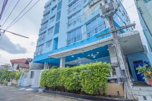 un edificio blu con un cespuglio davanti di Utopia Kata By RoomQuest a Phuket
