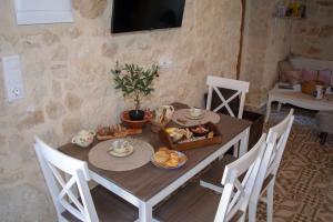 una sala da pranzo con tavolo e cibo di The Secret Ontas, Traditional stone house a Rethymno