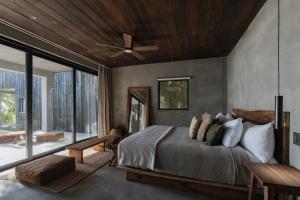 a bedroom with a bed and a ceiling fan at Umi Tulum in Tulum