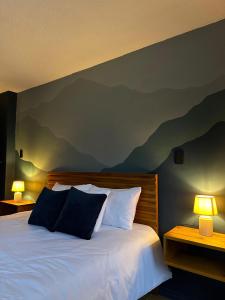 Hotel Agave Baños في بانوس: غرفة نوم مع سرير مع جبال مرسومة على الحائط