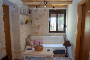 ein Wohnzimmer mit einem weißen Sofa und einem Fenster in der Unterkunft The Secret Ontas, Traditional stone house in Rethymno