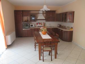 a kitchen with a wooden table with chairs and a table sidx sidx sidx at B&B Casa Piva in Serravalle