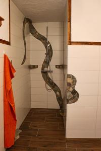 une sculpture de serpent dans une douche dans la salle de bains dans l'établissement Manggehof, à Grosshattenberg