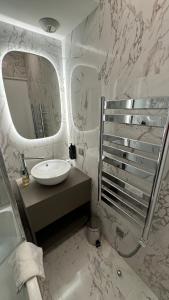 uma casa de banho branca com um lavatório e um espelho em Penthouse vue mer et jacuzzi privé em Antibes