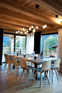 una sala da pranzo con un grande tavolo e sedie in legno di Chalet de montagne a Samoens avec jacuzzi et vue imprenable a Samoëns