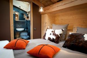 una camera da letto con un letto con cuscini arancioni e un lavandino di Chalet de montagne a Samoens avec jacuzzi et vue imprenable a Samoëns