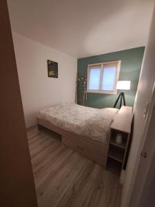 - une petite chambre avec un lit et une fenêtre dans l'établissement Chez Marie, à La Chapelle-Saint-Luc