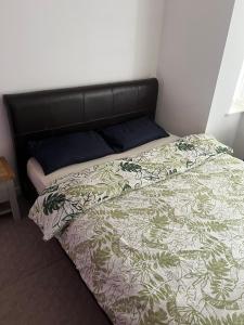 een bed met een groen en wit dekbed in een slaapkamer bij Central Birmingham in Birmingham