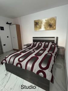 a bedroom with a bed with a red and white comforter at Maria’s studio in Paphos City