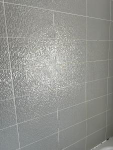 a white tiled wall in a bathroom at Central Birmingham in Birmingham
