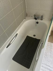 a bath tub with a black mat in it at Central Birmingham in Birmingham
