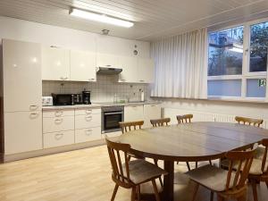 uma cozinha com uma mesa de madeira e cadeiras numa cozinha em Spacious workers loft in Pforzheim em Pforzheim