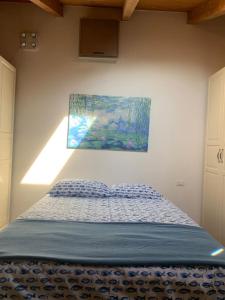 Ce lit se trouve dans une chambre ornée d'une peinture murale. dans l'établissement Appartamento in centro - San Giovanni in Persiceto, à San Giovanni in Persiceto