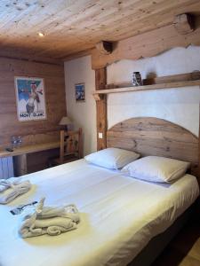 a bedroom with a large white bed in a cabin at Chalet Hôtel du Mont-Charvin & Spa in Crest-Voland