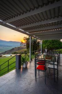 un patio con tavolo, sedie e vista sul tramonto di Graceland Self-Catering Cottages a Winterton