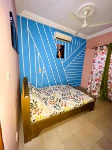 um quarto com uma cama com uma parede azul em Résidence meublée em Ouagadougou