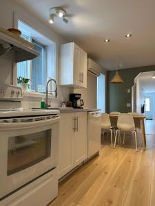 uma cozinha com electrodomésticos brancos e uma sala de jantar em Le 315B Limoilou "parking inclus" em Cidade de Quebec