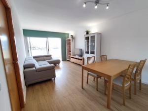ein Wohnzimmer mit einem Tisch und einem Sofa in der Unterkunft Apartamento a 150m de la playa con piscina y parking in Sant Antoni de Calonge